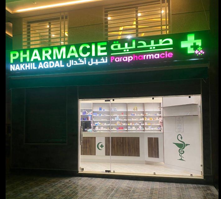 Façade de la Pharmacie Nakhil Agdal à Oujda, avec son enseigne lumineuse verte